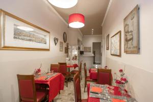 una sala da pranzo con tavoli e sedie con vestiti rossi di Hotel Masaccio a Firenze