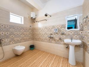 a bathroom with a sink and a toilet and a mirror at Hotel The Four Square in Digha +20 photos
