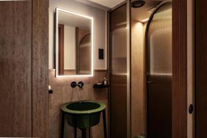 a bathroom with a green sink and a mirror at Romègas Hotel in Valletta