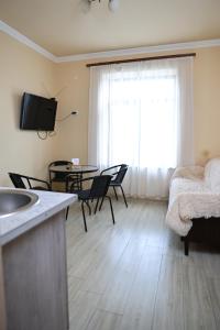 a living room with a table and chairs and a television at Liga Hotel and Restaurant in Shinuhayr