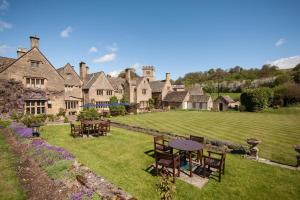an estate with tables and chairs on a lawn at Buckland Manor - A Relais & Chateaux Hotel in Broadway