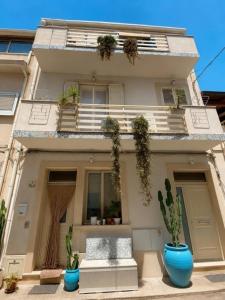 a building with two blue pots in front of it at Casa Mamà in Marzamemi