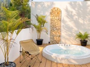 a chair and a tub in a room with plants at Hanara Bohemian Villa in Bandung