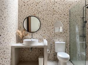 a bathroom with a sink and a toilet and a mirror at Hanara Bohemian Villa in Bandung