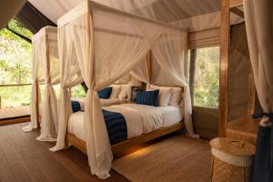 a bedroom with a bed with a canopy at Visama Explorer Nan in Ban Huai Luk