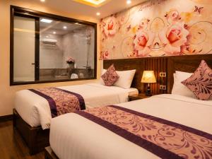 a hotel room with two beds and a window at Lavender SaPa Hotell & Spa - Free foot soak service in Sapa