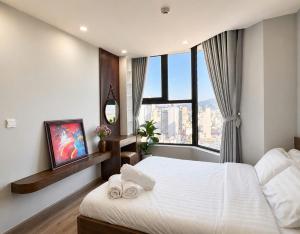 a bedroom with a large white bed and a window at 2-3 bedroom at HUD building Nha Trang in Nha Trang