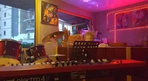 a room with drums and a bar with pink lights at Super Hostel in Nonthaburi