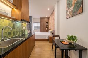 a kitchen with a sink and a room with a bed at An Hiên Home in Danang