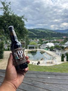 a person holding a beer bottle in their hand at Fazenda Fishbone, будиночок White fish in Verkhovyna +6 photos
