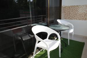 three white chairs and a table on a balcony at Sunny Beach Residence in Jomtien Beach