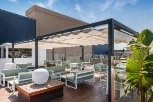 a patio with tables and chairs under a canopy at Salles Ciutat del Prat Barcelona Airport in El Prat de Llobregat