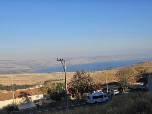 a white van parked in a parking lot next to a body of water at Kinneret view with pool in Safed