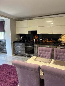 a kitchen with a table and purple chairs at Spacious apartment with a beautiful view in Căuşeni