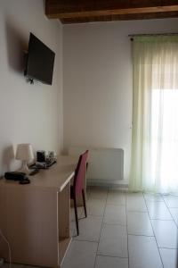 a room with a desk with a computer and a window at Alloggio Le Macine in Ferrara
