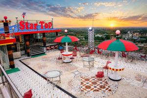 a patio with tables and chairs on top of a building at Star International Rajshahi - Near Aam chattar in Rājshāhi