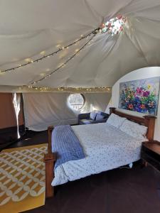 a bedroom with a bed in a tent at Little River Glamping in Ballymoney