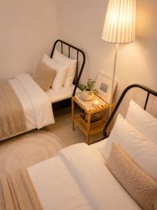 a room with two beds and a table with a lamp at BLAU Korean Local Experience Stay in Gyeongju