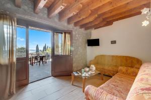 a living room with a couch and a sliding glass door at Agriturismo Cascina Crocelle - Lake View and Heated Pool in Padenghe sul Garda