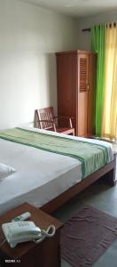 a bedroom with two beds and a table with a phone at Lotus villa lake resort in Matara