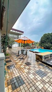 a patio with an umbrella and a swimming pool at Lotus villa lake resort in Matara +6 photos