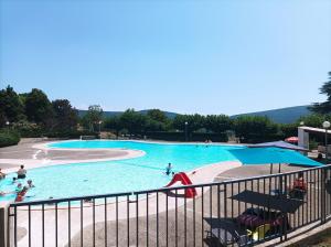 a large swimming pool with people in the water at belles chambres d'hôte, spacieuses et paisibles, en pays de Forcalquier in Saint-Étienne-les-Orgues