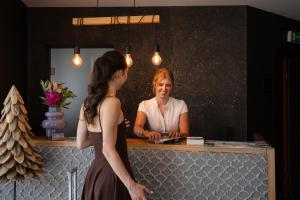 a woman looking at her reflection in a mirror at Margarethenstein Boutique Hotel including Zell am See Kaprun summercard and Air condition in Kaprun