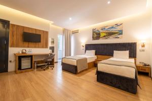 a hotel room with two beds and a desk at Business Life Hotel & SPA Bakırköy in Istanbul
