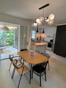a kitchen and dining room with a wooden table and chairs at Le Verger in Aix-en-Provence