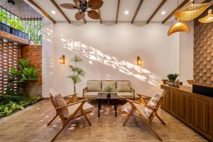 a living room with a couch and a table and chairs at An Hiên Home in Danang