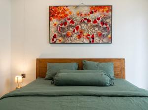 a bedroom with a bed with a painting on the wall at Private Cabin in Bandung
