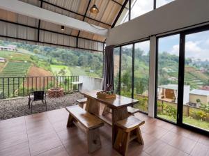 a room with a table and benches and windows at Private Cabin in Bandung