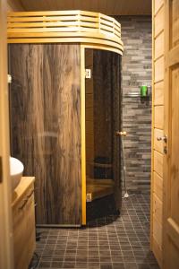 a bathroom with a shower with a glass door at ELK Aurora Lodge in Kakslauttanen