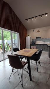 a kitchen with a wooden table and chairs in a room at Villa MegaLit - відпочинок у котеджах з чанами біля Косино та Берегово in Velyka Bihanʼ +36 photos