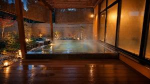 a building with a hot tub in the middle of a courtyard at Fujinomori Hotel in Fujikawaguchiko