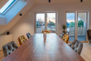 a large wooden table in a room with chairs at Loft-Apartment Schloßsee in Salem