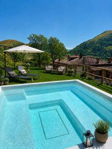 a swimming pool in front of a house at Agriturismo Pettino in Campello sul Clitunno
