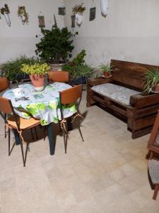 a patio with a table and a bench and potted plants at Living Bouganville in Trapani