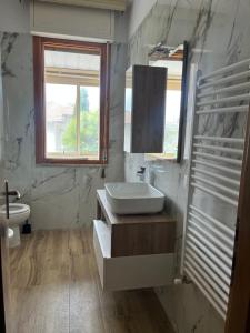 a bathroom with a sink and a toilet and a window at Casa Riotorto in Riotorto +4 photos