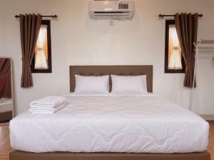 a bed with white sheets and pillows in a bedroom at Heavenly 2 - Private Triangle in Bandung