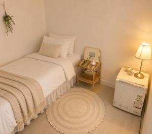 a bedroom with a bed and a table with a lamp at BLAU Korean Local Experience Stay in Gyeongju