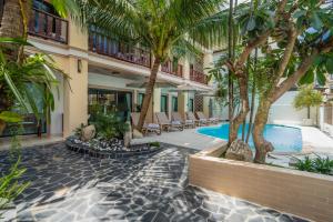 a resort with a swimming pool and palm trees at Westkey Patong Hotel in Patong Beach