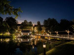 ein Gebäude mit einer Brücke über einen Fluss bei Nacht in der Unterkunft Pawlow History Hotel in Wolkenstein