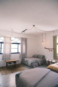 a bedroom with two beds and a table and windows at Island River in Green Island