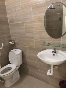 a bathroom with a toilet and a sink and a mirror at Quốc Ân Motel in Long Hai +97 photos