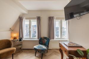 salon z krzesłem, stołem i oknami w obiekcie LOT Hotel w Lejdzie