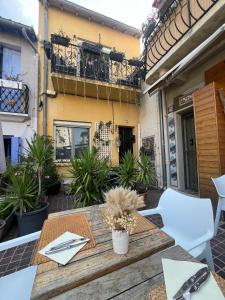 a table and chairs on a patio with a balcony at jolie maison de pêcheurs in Palavas-les-Flots