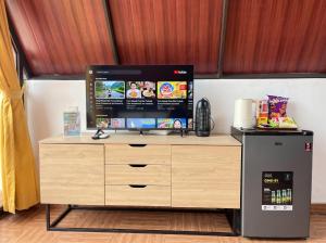 a television on top of a wooden stand next to a refrigerator at Heavenly 1 - Private Triangle in Bandung +3 photos