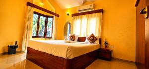 a bedroom with a bed in a room with yellow walls at Asif 3 bedroom luxury villa with swimming pool and kitchen in Nagoa-Bardez