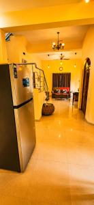 a kitchen with a refrigerator and a living room at Asif 3 bedroom luxury villa with swimming pool and kitchen in Nagoa-Bardez